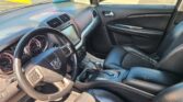 Interior of a car with black leather seats, steering wheel, center touchscreen, and gear shifter visible on the center console.