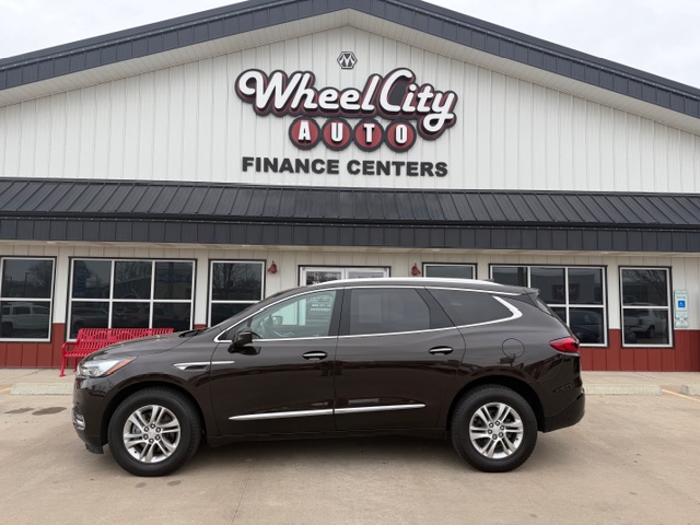 Brown SUV parked in front of Wheel City Auto Finance Centers dealership storefront.