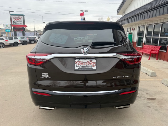 Rear view of a black Buick Enclave SUV at a dealership lot, showing the Buick emblem, Enclave badge, and a Wheel City Auto Finance Centers license plate frame.