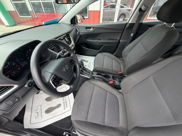 Gray front interior of a Hyundai with the steering wheel, driver and passenger seats, center console, and dashboard.