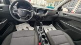 Front interior of a Hyundai car displaying the steering wheel, dashboard with touchscreen, center console, gear shifter, and two front seats.