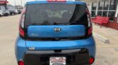 Rear view of a blue Kia Soul parked in a dealership lot, showing the Wheel City license plate frame and black lower bumper.