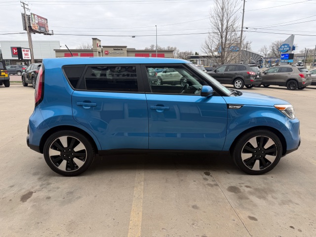 Blue compact crossover SUV shown in a side profile parked in a parking lot, featuring black alloy wheels and dark-tinted rear windows.