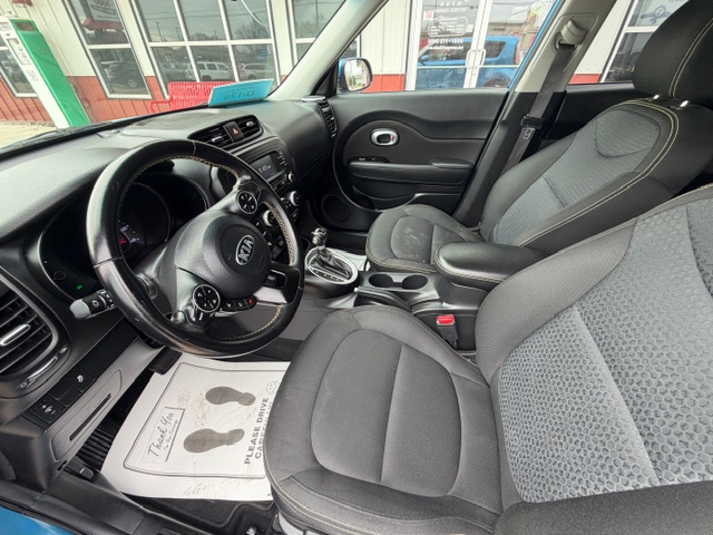 Interior of a dark gray SUV: front seats, steering wheel, center console, and automatic gear shifter visible from the driver’s side.
