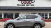Gray SUV parked in front of Wheel City Auto Finance Centers dealership building with large sign above the entrance.