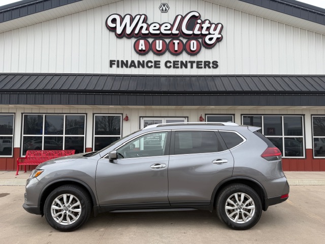 Gray SUV parked in front of Wheel City Auto Finance Centers dealership building with large sign above the entrance.