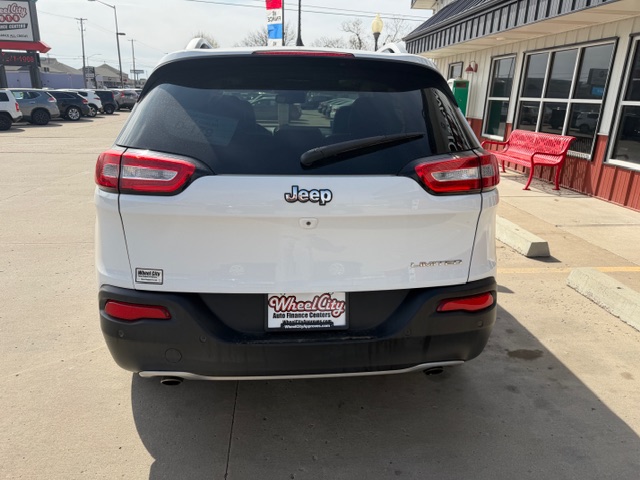 Rear view of a white Jeep SUV in a dealership lot with a Wheel City license plate frame.