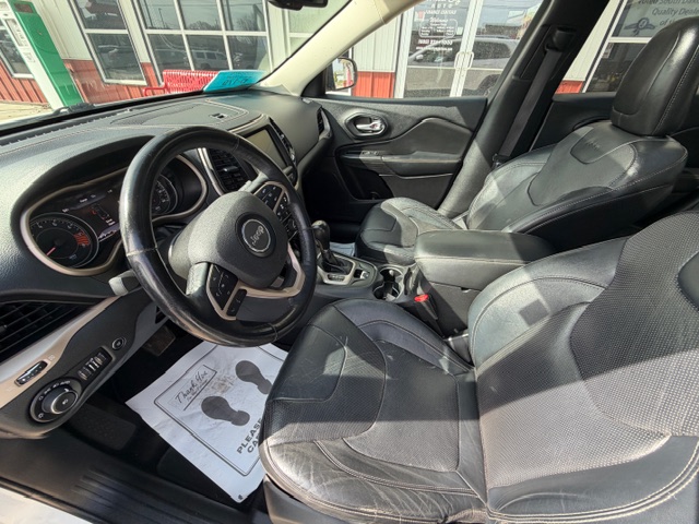 Front interior of a black SUV with leather seats, steering wheel, and center console visible (Jeep).