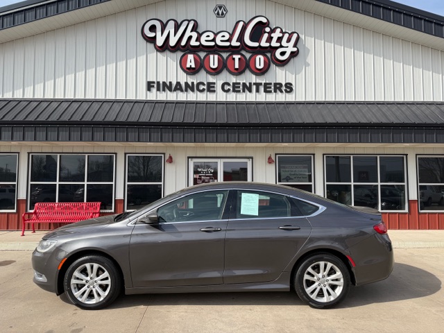 Gray four-door sedan parked in front of Wheel City Auto Finance Centers storefronts.