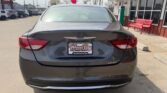 Rear view of a dark gray Chrysler 200 sedan parked at a dealership, with a Wheel City Auto Finance Center license plate frame visible on the trunk.