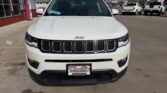 Front view of a white Jeep SUV parked at a car dealership, with a Wheel City Auto Finance Centers license plate frame visible on the front bumper.