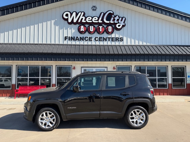 Black Jeep Renegade SUV parked in front of Wheel City Auto Finance Centers storefront.