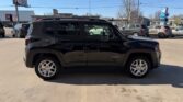 Side view of a black midsize SUV with roof rails parked in a sunny parking lot.