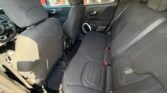 Interior of a car showing the rear passenger seat area with a three-seat bench and dark fabric upholstery, headrests visible.