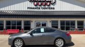 Gray two-door coupe parked in front of Wheel City Auto Finance Centers storefront signout front.