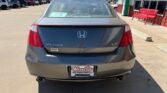 Rear view of a gray Honda Accord V6 at a car dealership, showing taillights, dual exhausts, and a Wheel City license plate frame.