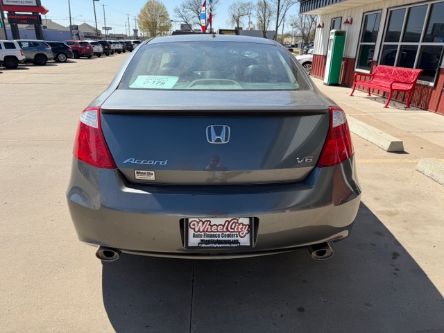 Rear view of a gray Honda Accord V6 at a car dealership, showing taillights, dual exhausts, and a Wheel City license plate frame.
