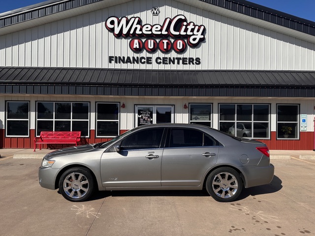 Silver sedan parked in front of the Wheel City Auto Finance Centers storefront.
