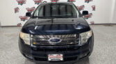 Front view of a dark blue Ford SUV inside a showroom with a white backdrop branded 'Wheel City Auto Finance Centers' repeated across the wall.