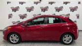 Red sedan indoors in front of a white backdrop covered with Wheel City Auto Finance Centers logos.