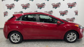 Red sedan parked indoors in front of a white backdrop with Wheel City Auto Finance Centers logos visible across the wall.