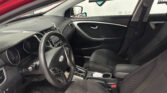Interior of a car viewed from the driver's seat, showing steering wheel, dash, center console, and front passenger seat with seatbelt visible