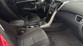 Interior of a car showing front seats, steering wheel, center console, and gear shifter inside a red exterior vehicle