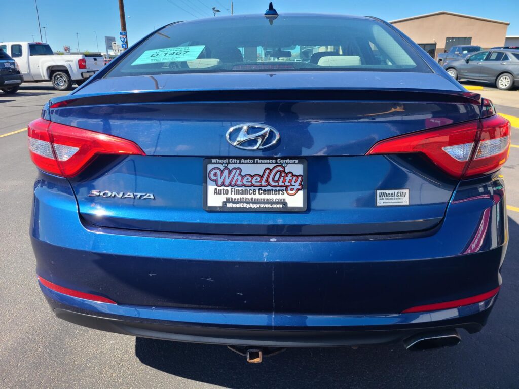 Blue Hyundai Sonata rear view in a car dealership lot with a Wheel City dealer plate visible on the bumper.