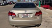 Beige Lexus sedan photographed from the rear in a car dealership lot, with a Wheel City Auto Finance Centers plate on the back.