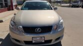 Front view of a beige Lexus sedan in a dealership parking lot, Wheel City license plate frame visible on the bumper.