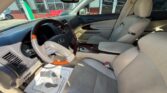 Front interior of a beige leather SUV, featuring a wood-trim steering wheel, center console, and front seats
