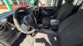 Interior view of a dark SUV showing the steering wheel, dashboard, and front seats with a center console between them.