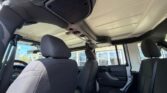 Interior of a vehicle with black fabric seats, showing front and rear rows and an overhead console exposed to the cabin.