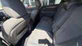 Rear interior of a sedan with gray fabric seats, showing the back row and part of the front seats in daylight.