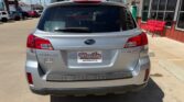 Rear view of a silver Subaru Forester in a dealership lot, Wheel City license plate frame and red benches nearby.