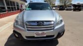 Front view of a silver Subaru SUV parked outside a dealership, Wheel City license plate frame visible on the bumper.