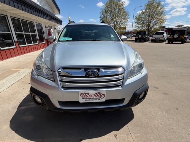 Front view of a silver Subaru SUV parked outside a dealership, Wheel City license plate frame visible on the bumper.