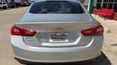 Rear view of a silver Chevrolet sedan parked at a dealership, showing the Chevrolet badge and a Wheel City Auto Finance Centers license plate frame on the trunk.