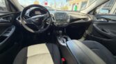 Interior of a Chevrolet car showing the driver and passenger seats, steering wheel, and center console with a touchscreen display.