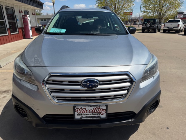 Front view of a silver Subaru SUV in a dealership lot, chrome grille with the Subaru emblem and a Wheel City license plate