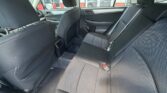Rear passenger area of a dark fabric SUV/car with back seats, headrests, and visible seat belts.