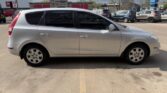 Side view of a silver compact hatchback parked in an outdoor parking lot.