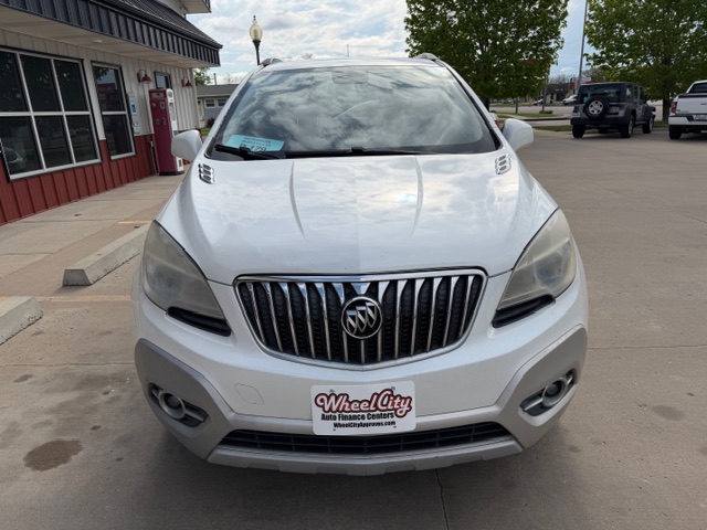 Front view of a white Buick SUV parked in a dealership lot with Wheel City license plate frame in foreground.