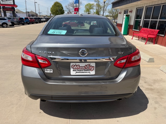 Rear view of a gray Nissan Altima SV in a dealership lot, showing the Wheel City plate frame.