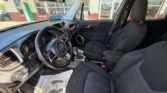 Dark gray SUV interior with the front seats, steering wheel, center console, and floor mat visible; driver’s side door open showing exterior scene outside the vehicle.