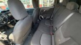 Interior view of a dark fabric SUV showing the front seat, steering wheel, and a rear bench seat for three with visible seat belts