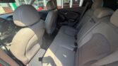 Interior of a car showing gray cloth seats (front two and rear bench) with door panels and center console, sunlit through the windows.