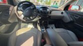 Interior view of a Hyundai SUV from the rear seats, showing steering wheel, center console, and front dashboard in daylight
