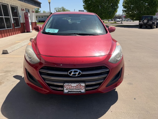 Front view of a red Hyundai car parked in a dealership lot, WheelCity license plate frame visible