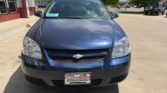 Front view of a blue Chevrolet sedan parked in a dealership lot with a Wheel City Auto Finance Centers license plate frame visible on the bumper.